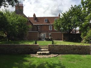 una gran casa de ladrillo con una pared de ladrillo y árboles en Beautiful Georgian House located in Blandford en Blandford Forum