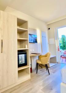 a living room with a tv and a desk and a chair at Hotel Tirreno in Parghelia