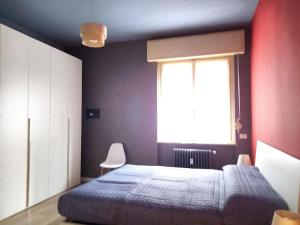 ein Schlafzimmer mit einem großen Bett und einem Fenster in der Unterkunft La casa di Anna, appartamento trilocale con balcone e garage in Brescia