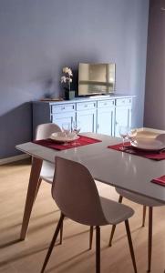 einem Esstisch mit 2 Stühlen und einem weißen Schrank in der Unterkunft La casa di Anna, appartamento trilocale con balcone e garage in Brescia