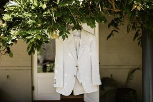 ein weißer Anzug hängt von einem Baum vor einer Tür in der Unterkunft The Woods Pokolbin in Pokolbin