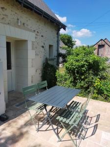 a picnic table and two chairs on a patio at Gîte Val de Loire accès privatif: 2/4 personnes in Saint-Branchs