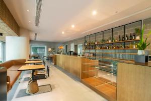 a restaurant with wooden tables and glass shelves at Atour X Shanghai Huaihai Middle Road in Shanghai