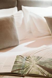 an open book on a bed with white sheets and pillows at Pimont Alpine Chalet in Madonna di Campiglio