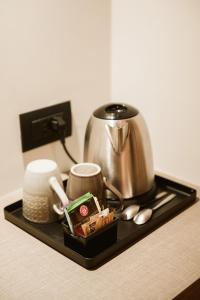 a black tray with a tea pot and a coffee pot at Pimont Alpine Chalet in Madonna di Campiglio