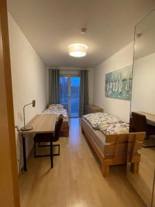 1 Schlafzimmer mit 2 Betten, einem Schreibtisch und einem Tisch in der Unterkunft Helle Wohnung mit Balkon 120qm, 4Zimmer in Dortmund