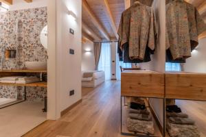 a room with wooden ceilings and a hallway with clothes hanging on hooks at B&B El Lares - B&B L'Avez in Canale dʼAgordo +178 photos