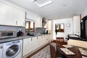 a kitchen with a washing machine and a dining room at The Owl House with private hot tub in Newport