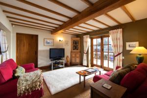 uma sala de estar com um sofá vermelho e uma televisão em The Owl House with private hot tub em Newport
