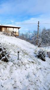 a snow covered hill with a house on top of it at Casa Veche Corbeni in Corbeni