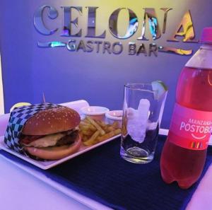 uma bandeja com uma sanduíche e batatas fritas e uma bebida em Hotel Villa Grant em Aguachica