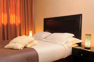 1 dormitorio con 1 cama grande con sábanas y almohadas blancas en Art suites en El Jadida