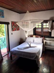 een slaapkamer met een bed met een witte baldakijn bij VILA LUMAR in Coroa Vermelha