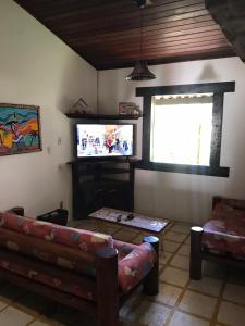 een woonkamer met een bank en een flatscreen-tv bij VILA LUMAR in Coroa Vermelha