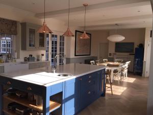 a kitchen with a blue island and a dining room at Beautiful Georgian House located in Blandford in Blandford Forum