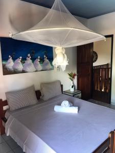 een bed met een witte baldakijn in een kamer bij VILA LUMAR in Coroa Vermelha
