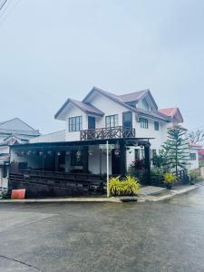 une maison blanche avec un restaurant dans une rue dans l'établissement D’Waldz Villa Tagaytay, à Tagaytay