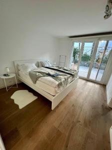 a white bedroom with a bed and a wooden floor at Casa Segnale in Ascona