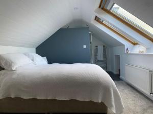 una camera con un letto bianco e una finestra di Modern holiday home with sea view- close to beach a Portstewart
