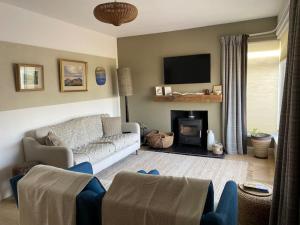 un soggiorno con divano e camino di Modern holiday home with sea view- close to beach a Portstewart