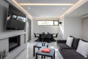 salon z kanapą i stołem w obiekcie Panorama Luxury Penthouse w miejscowości Ixiá
