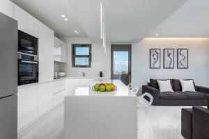 a white kitchen and living room with a couch at Panorama Luxury Penthouse in Ixia