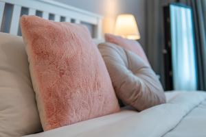 two pink pillows on a white couch with a lamp at Veluxa - Renovated! La Maison des Artist in Dubai +39 photos