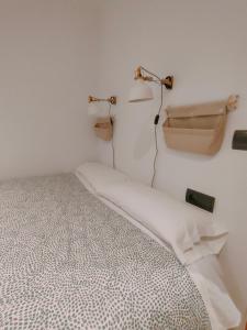 Camera bianca con letto e luci sul muro di Tirwal Suite San Juan a Teruel