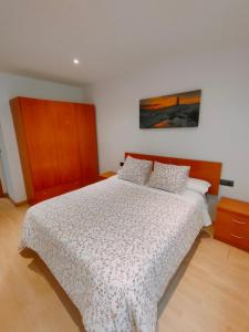 una camera da letto con un letto e un piumone bianco di Tirwal Suite San Juan a Teruel