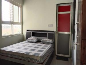- un lit avec deux oreillers dans une chambre dotée d'une fenêtre dans l'établissement HOTEL HOLIDAY HOME, DAUSA, à Dausa