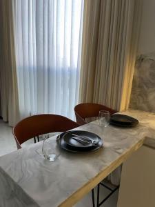 una mesa con dos platos y vasos encima en Smart Entry Apartment en Riad
