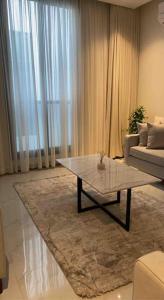 a living room with a table and a couch at Smart Entry Apartment in Riyadh