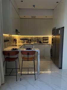 a large kitchen with a table and a refrigerator at Smart Entry Apartment in Riyadh
