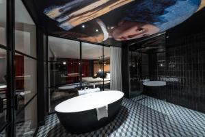 een badkamer met een groot bad en een schilderij aan het plafond bij Hôtel Baud - Teritoria in Bonne-sur-Ménoge
