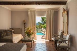 - une chambre avec un lit et une vue sur la piscine dans l'établissement Le Phébus & Spa – Relais & Châteaux, à Joucas