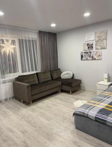 a living room with a couch and a bed at Crystal Twin Apartment in Gulbene