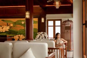 a woman sitting in a room with chairs at Senna Wellness Retreat in Bắc Ninh
