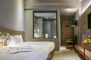 a hotel room with two beds and a mirror at Orient Luxury Hotel in Chiayi City