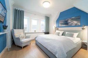 um quarto com uma cama grande e uma cadeira em Tanneneck Wohnung 2 em Travemünde