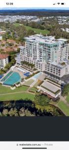 una vista aérea de un gran edificio de apartamentos con piscina en Resort One Bedroom Apartment, en Pelican Waters