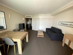 a living room with a table and a couch at Resort One Bedroom Apartment in Pelican Waters