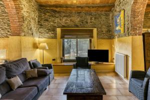 a living room with a couch and a table at Rural Mas Hortus in Girona