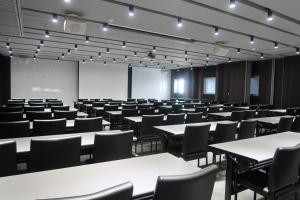 an empty lecture room with tables and chairs at Orient Luxury Hotel in Chiayi City