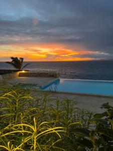 einen Sonnenuntergang über dem Meer mit Pool in der Unterkunft Villa GÊMEO vue mer, piscine accès privé plage in Calheta Do Maio