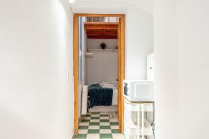 korytarz z drzwiami otwieranymi do pokoju z podłogą wyłożoną szachownicą w obiekcie Adorable apartamento en Almagro w Madrycie