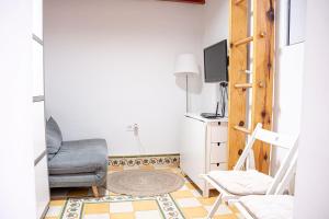salon z krzesłem i telewizorem w obiekcie Adorable apartamento en Almagro w Madrycie