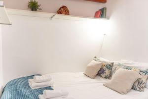 sypialnia z białym łóżkiem i ręcznikami na nim w obiekcie Adorable apartamento en Almagro w Madrycie