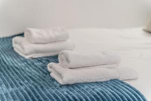stos ręczników leżący na łóżku w obiekcie Adorable apartamento en Almagro w Madrycie