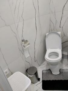 baño con aseo y cubo de basura en Молодежный, en Almaty