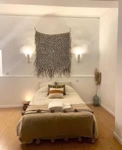 um quarto com uma cama grande e duas luzes na parede em La Maison du Trident en Camargue Piscine et Jacuzzi em Vauvert